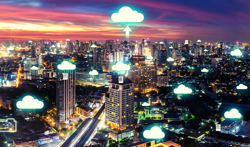 A photo of a digitally enhanced city landscape at sunset, with cloud icons shining above different skyscrapers