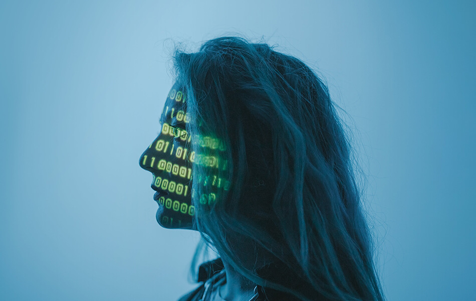 A human stares vacantly into the distance whilst green binary code is projected onto their face