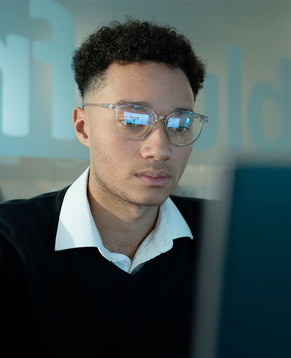 Brandon our Cyber Security Analyst working at a laptop in a meeting booth