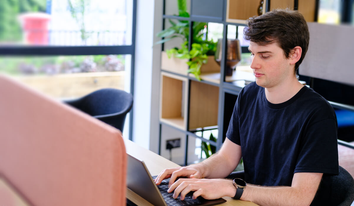 an AI specialist concentrating on their laptop in a bright office space