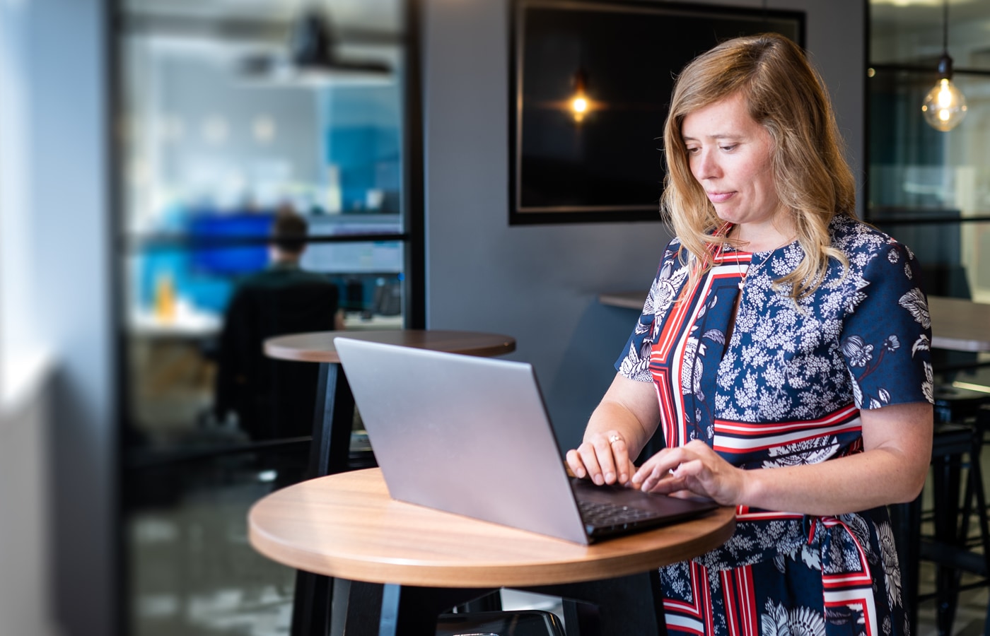 A smartly-dressed project manager works on their laptop