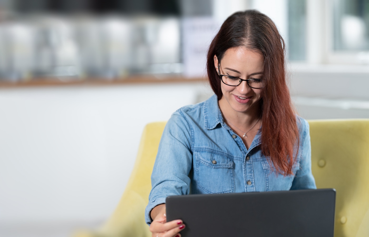 A customer smiles as they work on their laptop